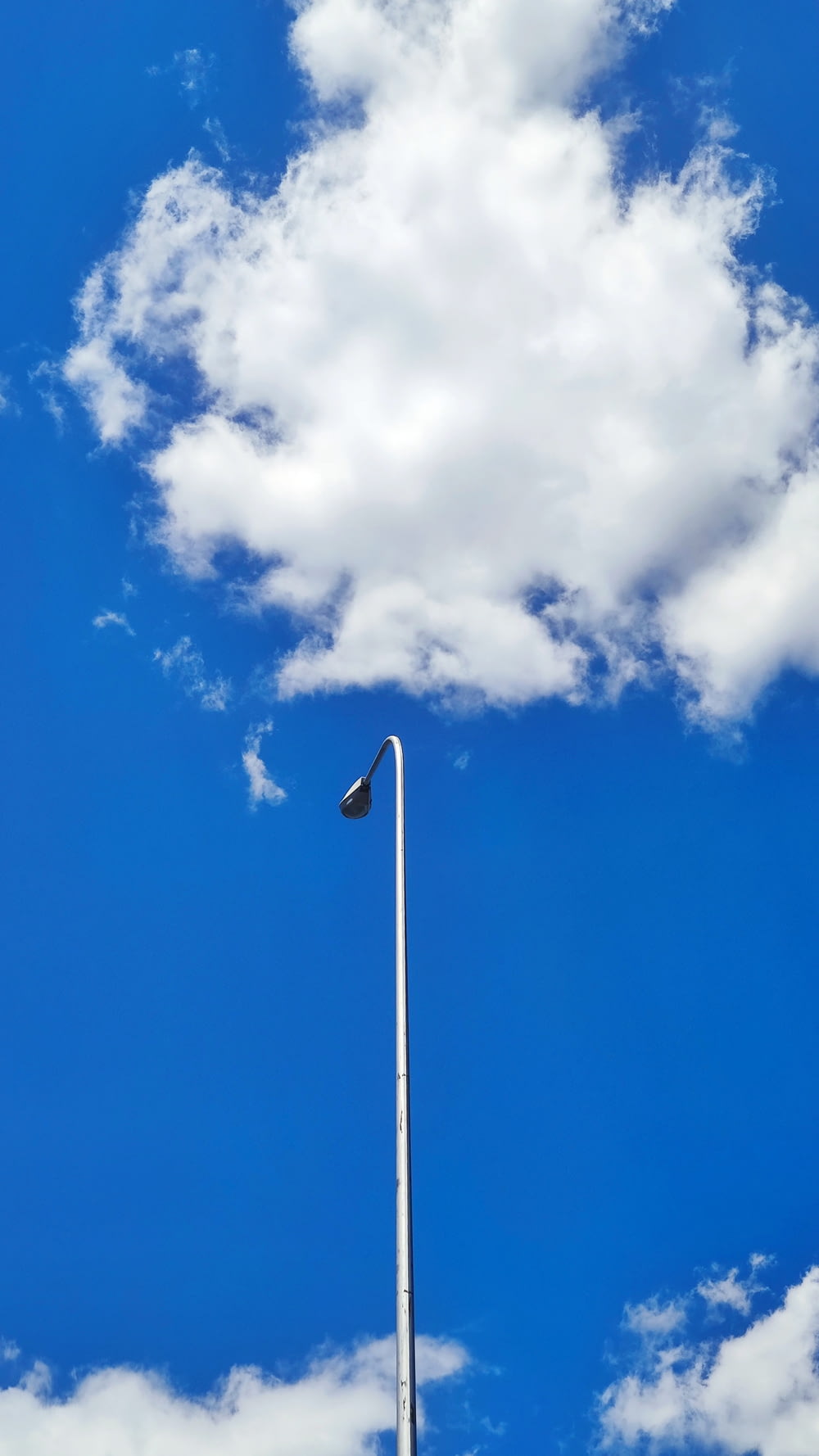 a tall flag pole in front of a blue sky