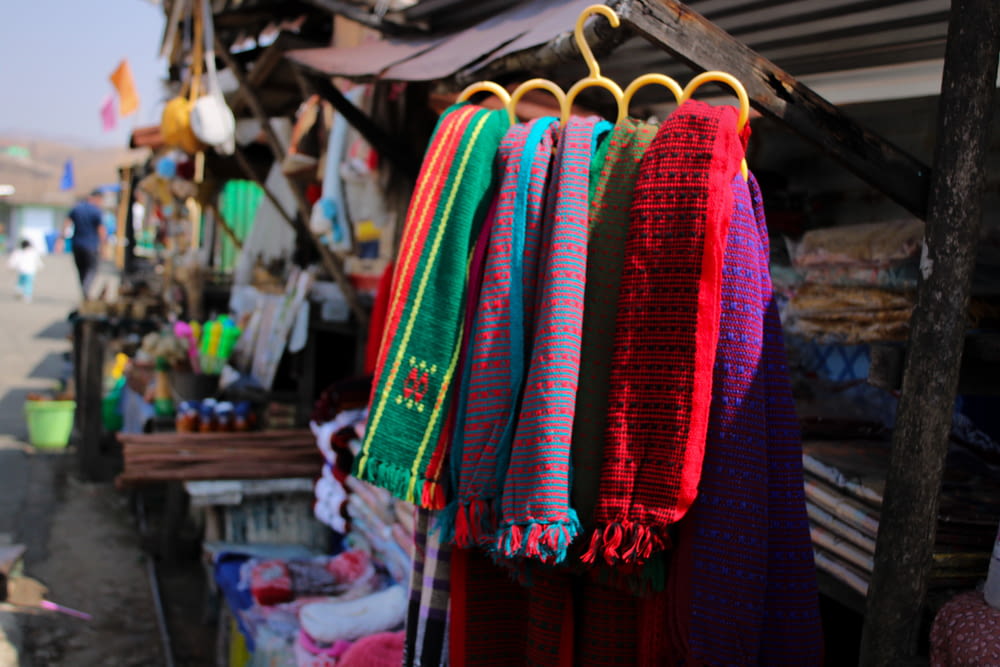 a bunch of colorful scarves hanging from a rack