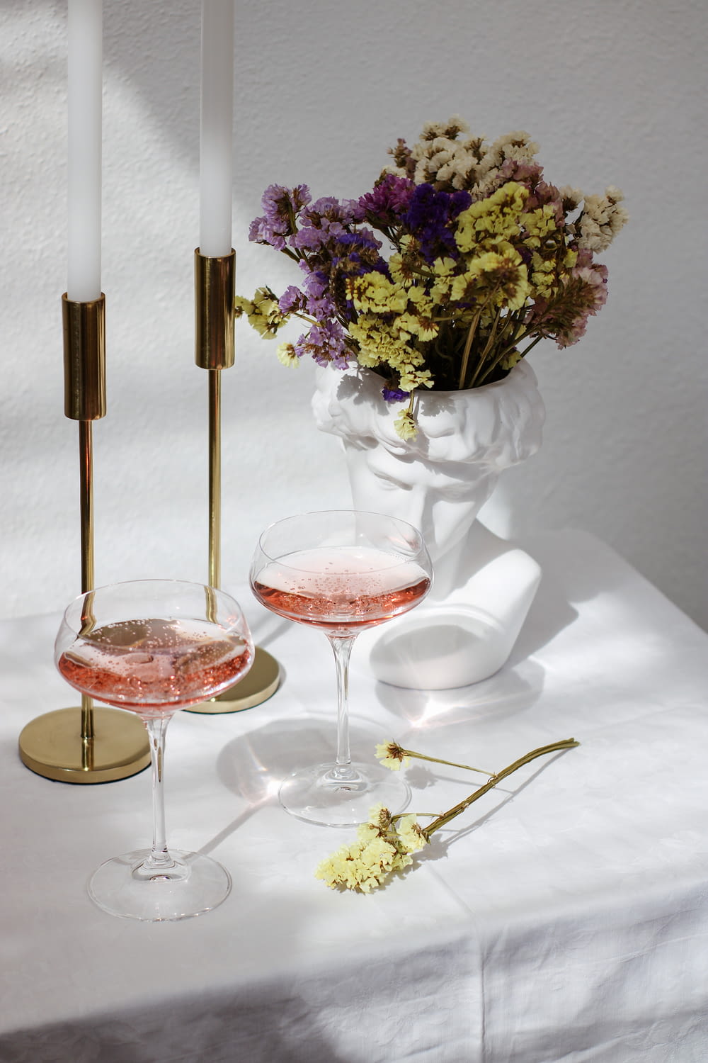 ein Tisch mit zwei Weingläsern und einer Vase voller Blumen