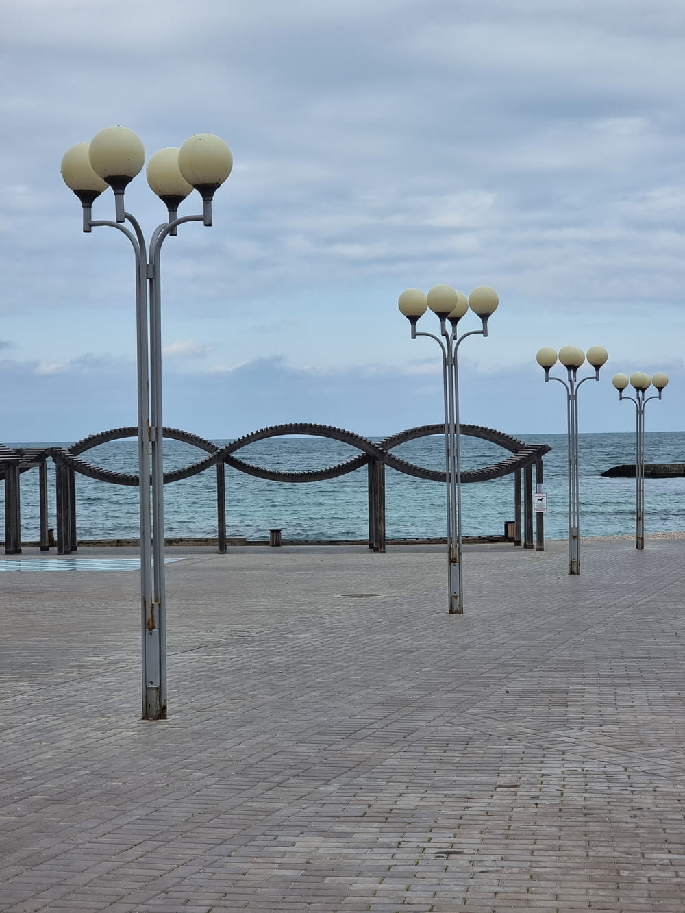 a row of street lamps sitting on top of a sidewalk
