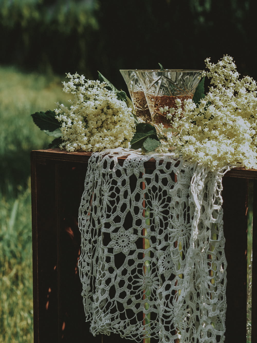 a table topped with a white table cloth and a vase filled with flowers