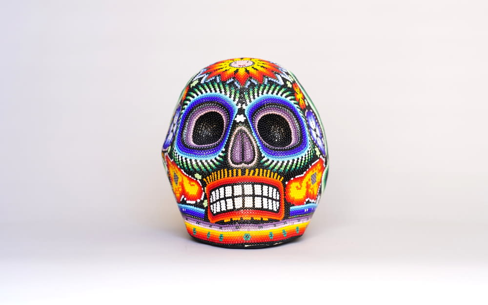 a colorfully painted sugar skull on a white background
