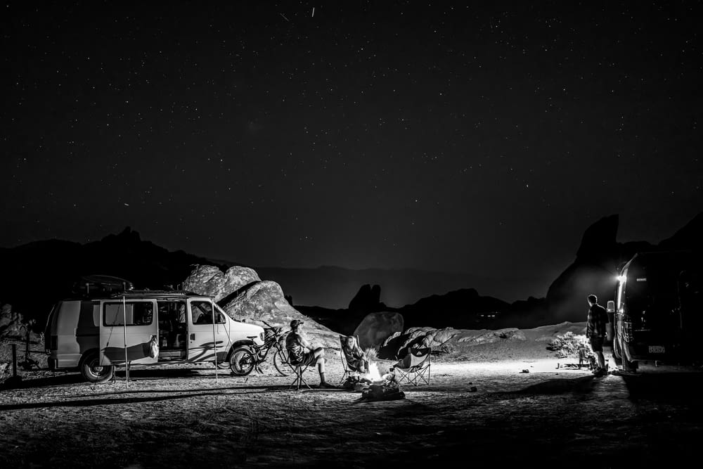 a black and white photo of a camp site at night