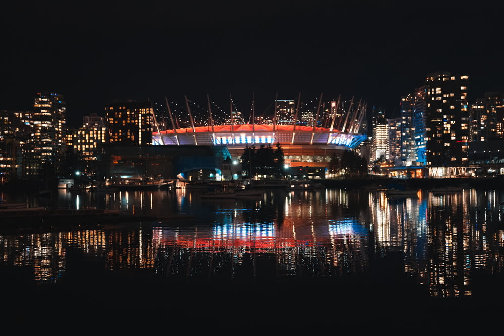 Eine Skyline der Stadt bei Nacht mit einem beleuchteten Stadion