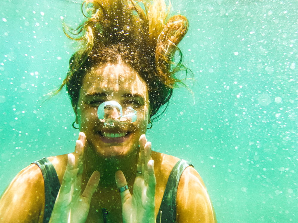 a woman under water with a bubble in her mouth