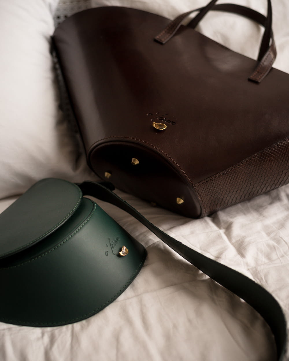 ベッドの上に座っている茶色と緑の財布
