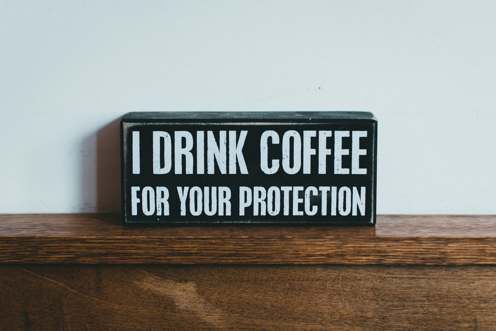 a sign that says i drink coffee for your protection