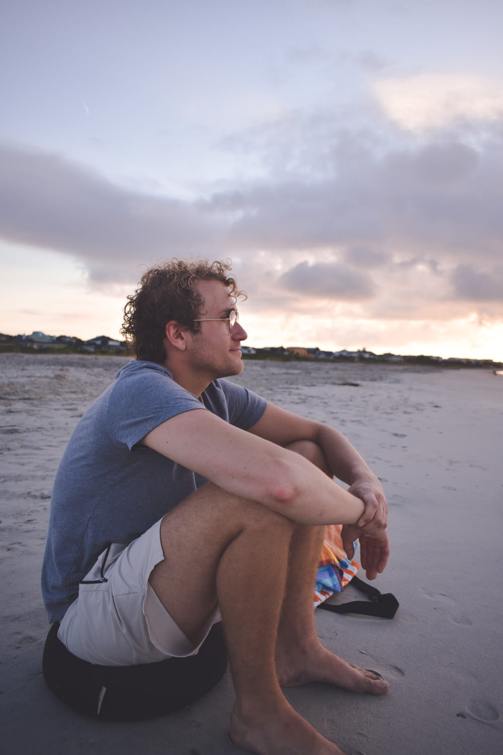 Ein Mann sitzt am Strand neben einem Drachen