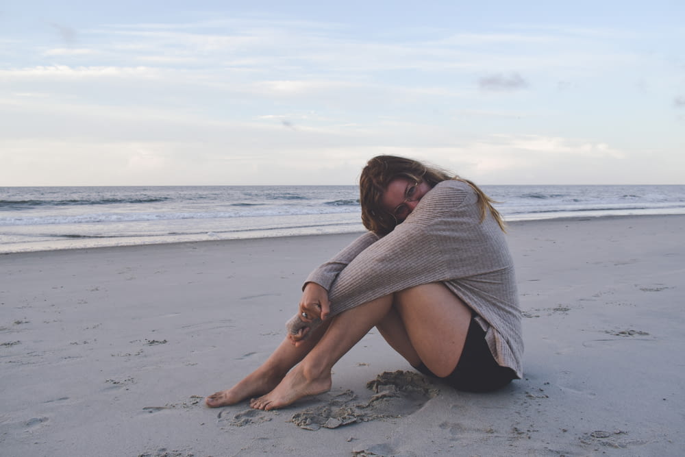 Eine Frau sitzt mit gekreuzten Beinen am Strand