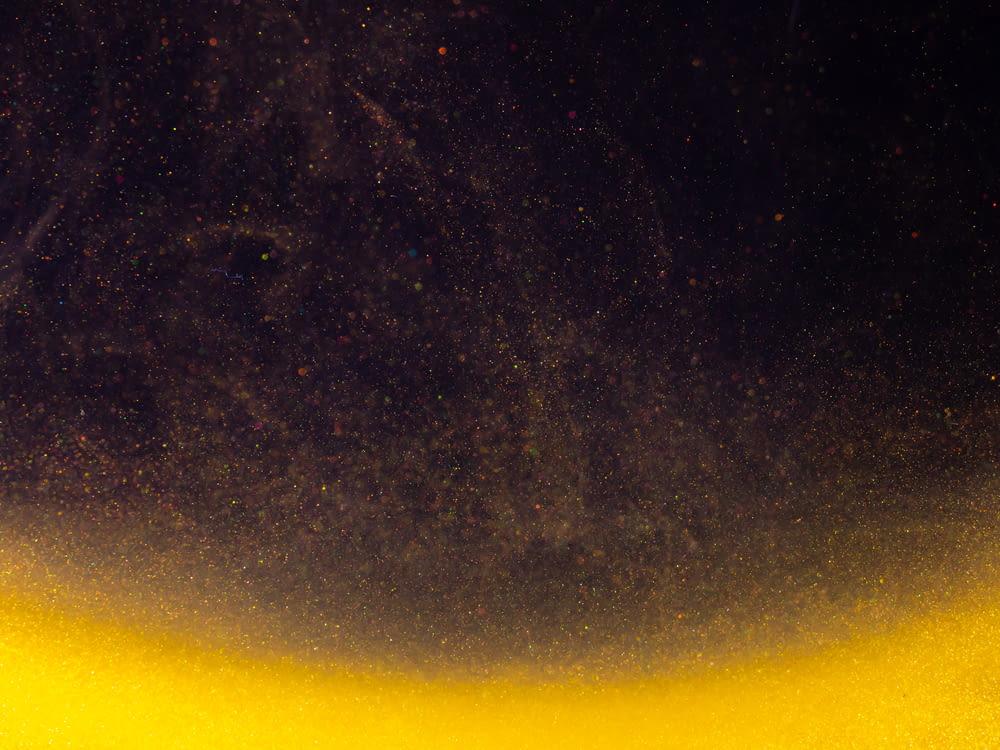 a black and yellow background with stars in the sky