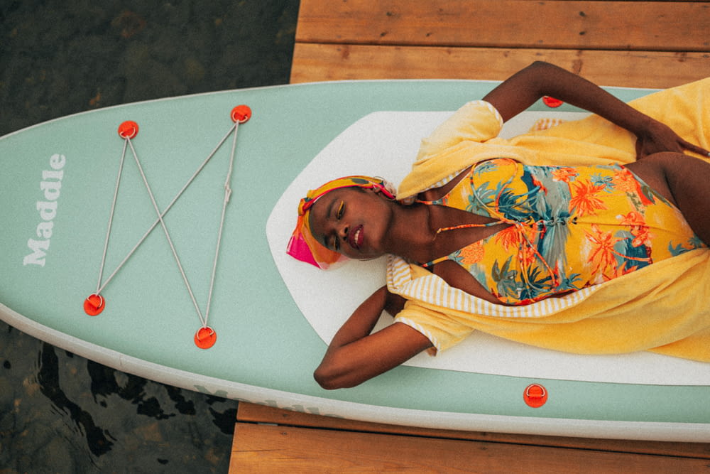 a woman laying on top of a surfboard