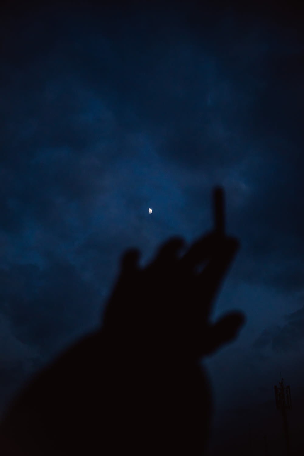 a person's hand with a moon in the background