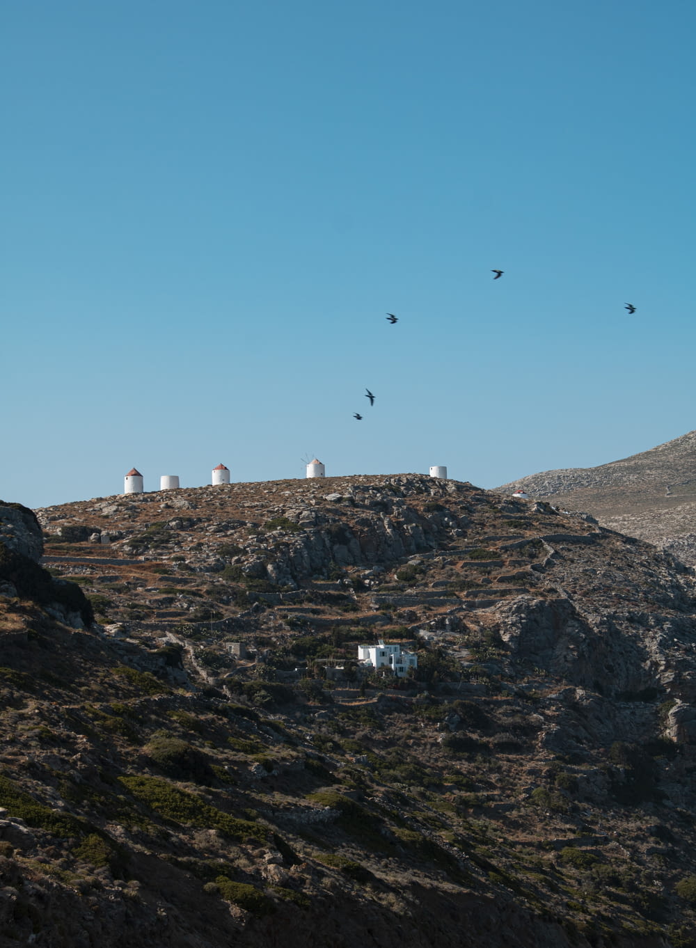 a group of white buildings on a rocky hill
