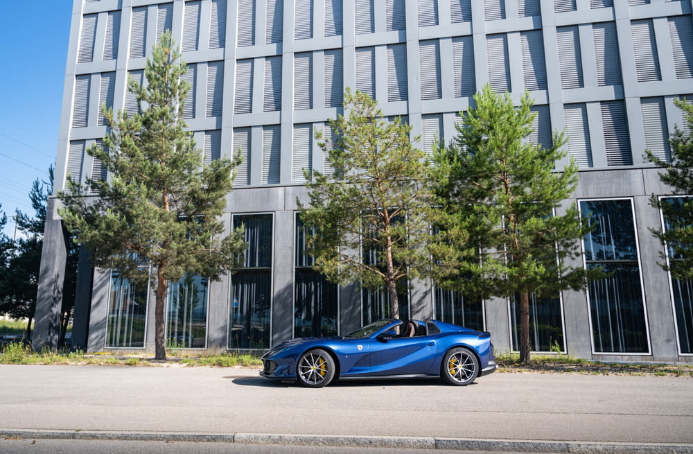a blue car parked in front of a building