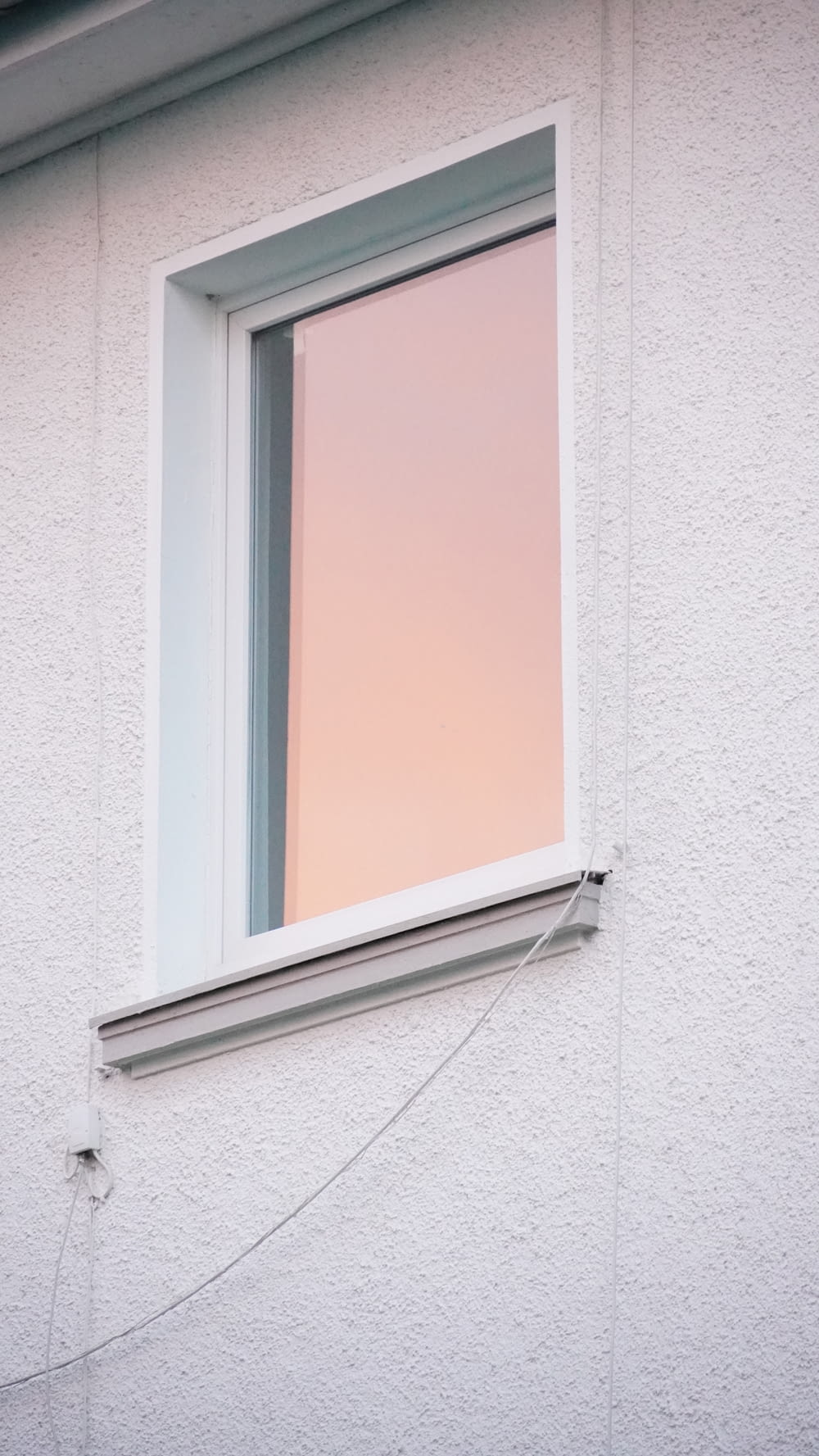 uma janela com uma cortina rosa