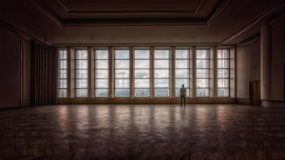 a person standing in a room with large windows