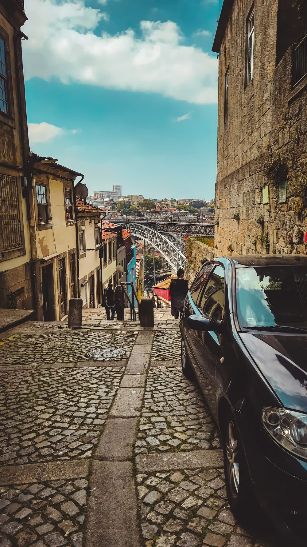 a car parked on a cobblestone street with buildings on either side