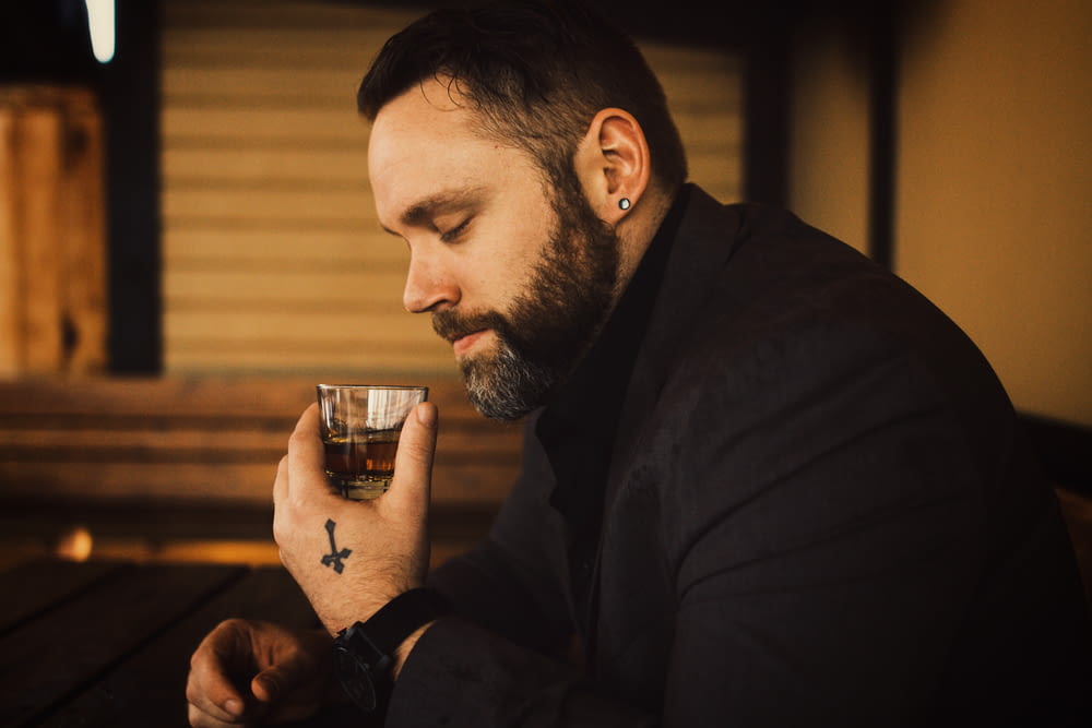 a man with a beard holding a drink