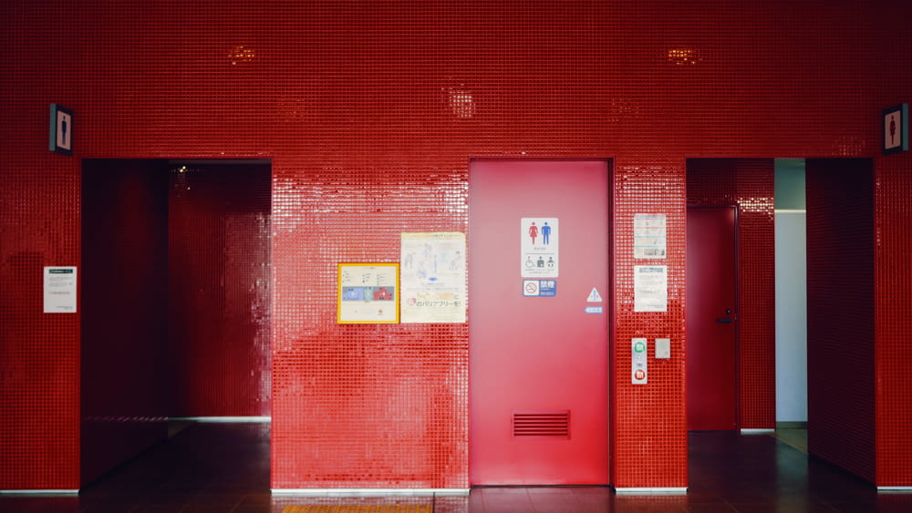 a red wall with a few doors