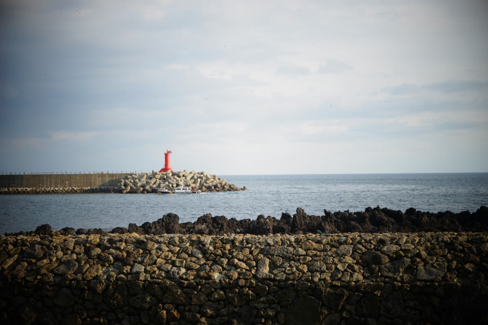 a rocky shoreline with a lighthouse