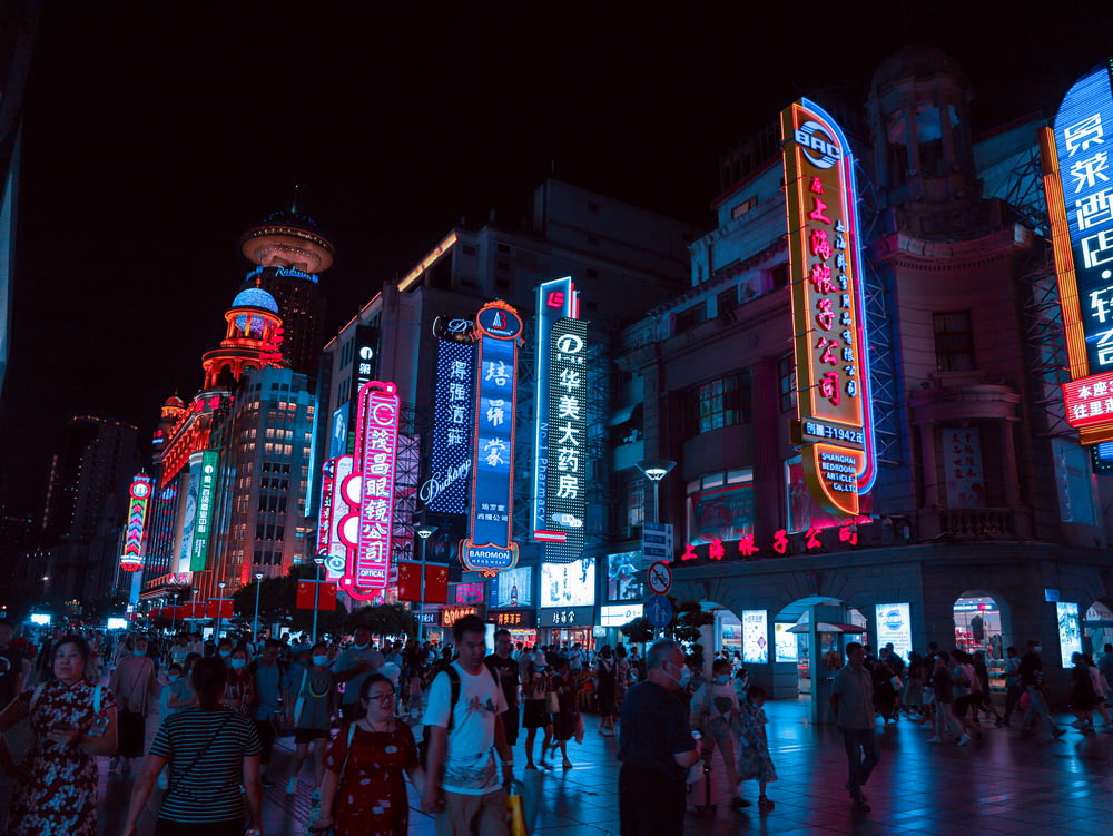 a crowd of people walking in a city at night
