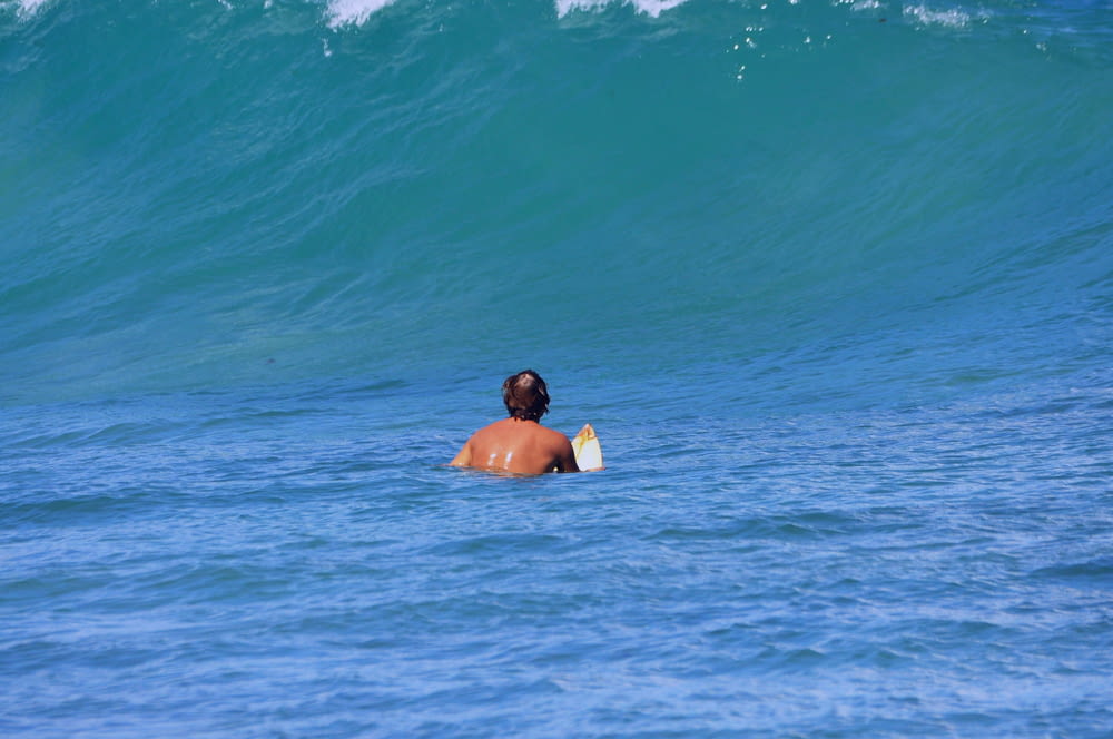 a man in the water with a surfboard