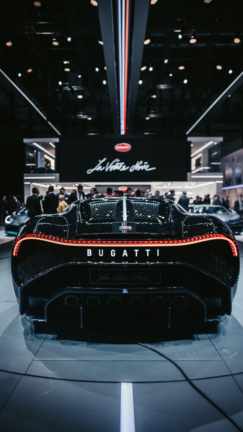 a black sports car with people in the background