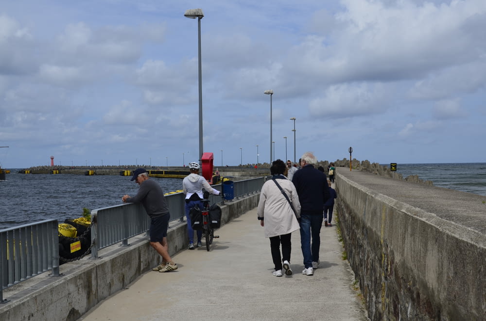 a group of people walking along a waterfront
