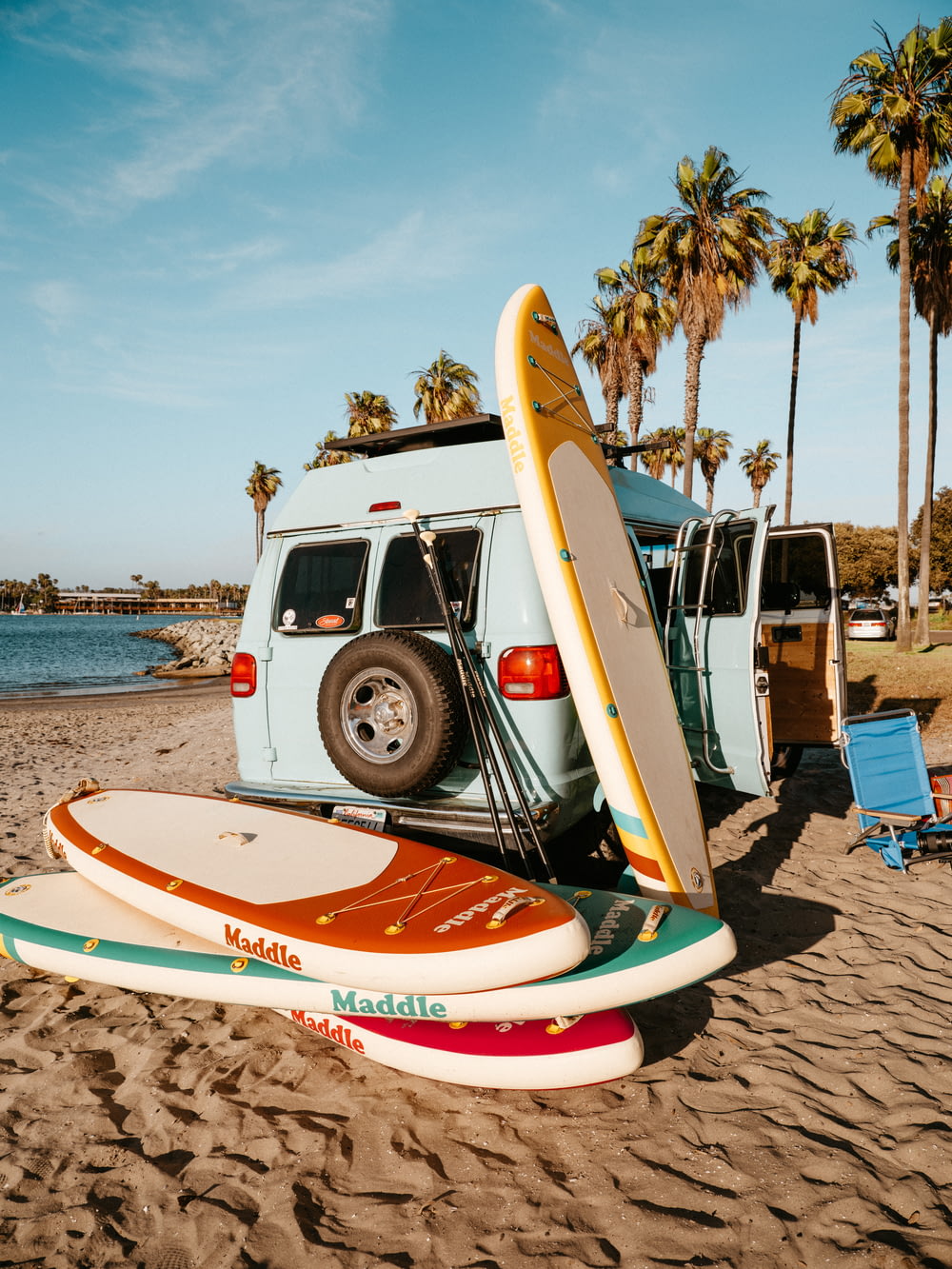 a van with surfboards on the beach