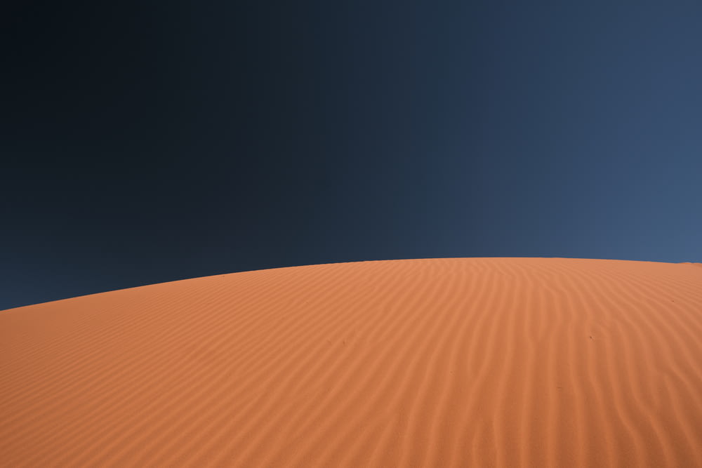 a sand dune with a blue sky