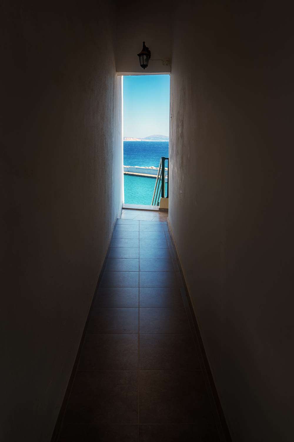 a hallway with a view of the ocean and a balcony