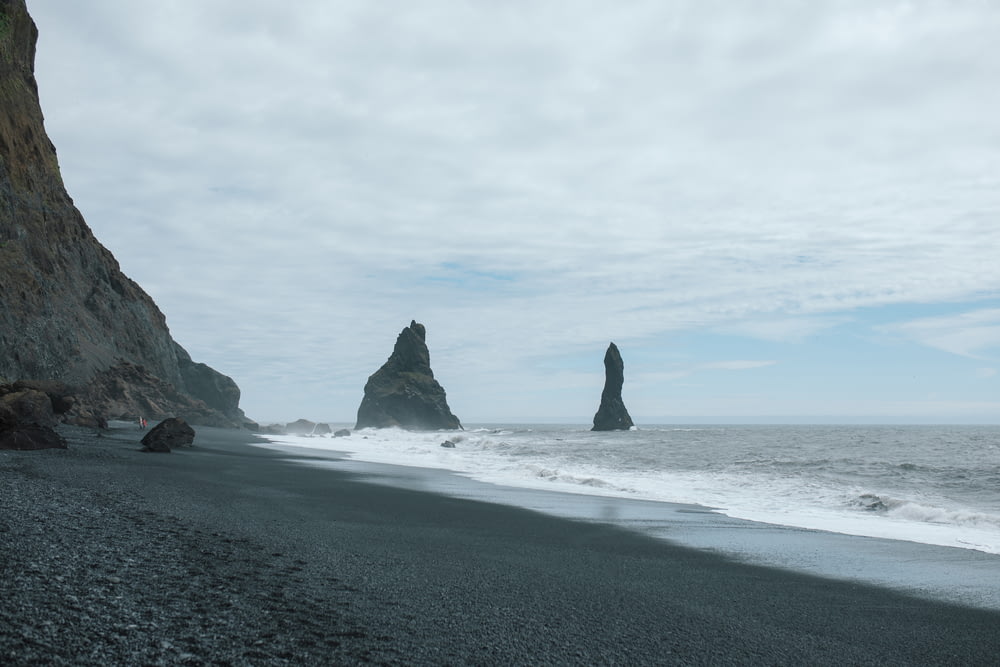 uma praia rochosa com um grande corpo de água ao fundo