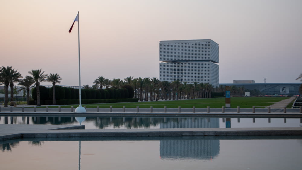 a body of water with a flag and a building in the background
