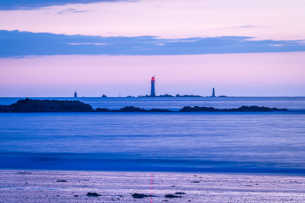 a body of water with a lighthouse in the distance