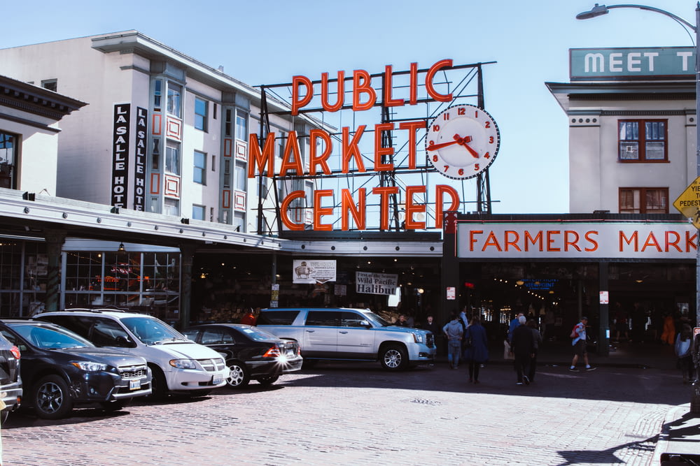 um grupo de pessoas fora de uma loja com o Pike Place Market ao fundo