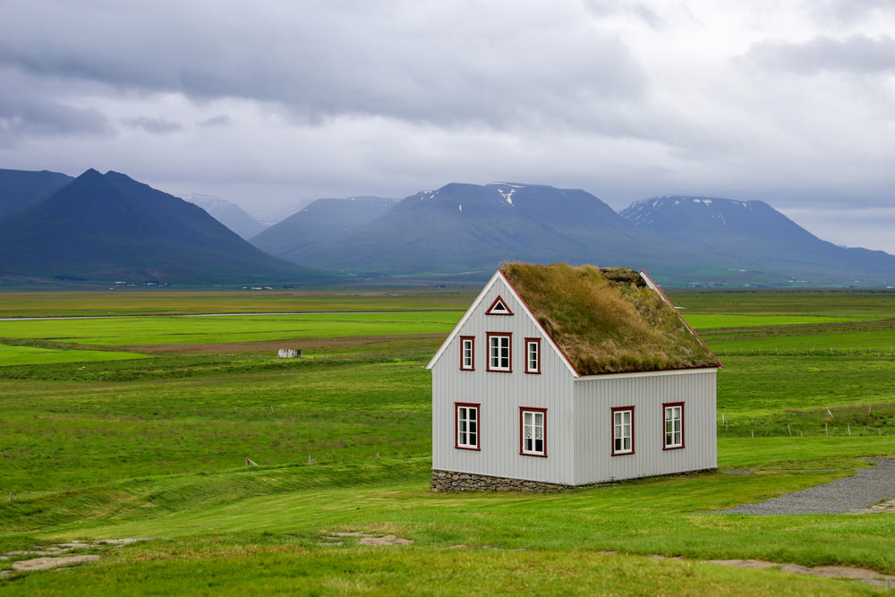 a white house in a green field