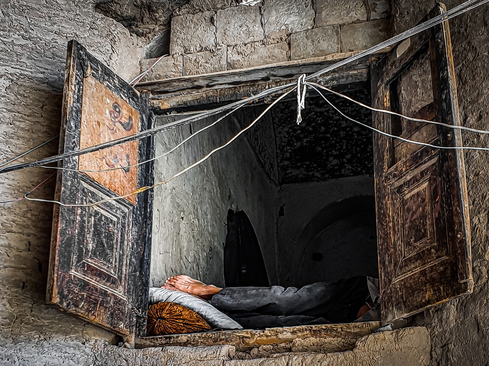 a person sleeping in a small stone tunnel