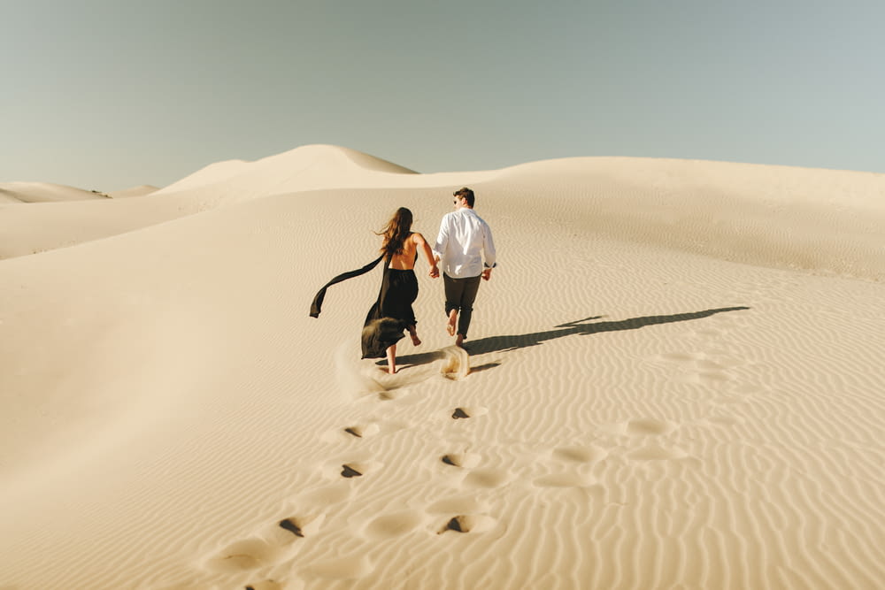 a man and woman walking in the desert