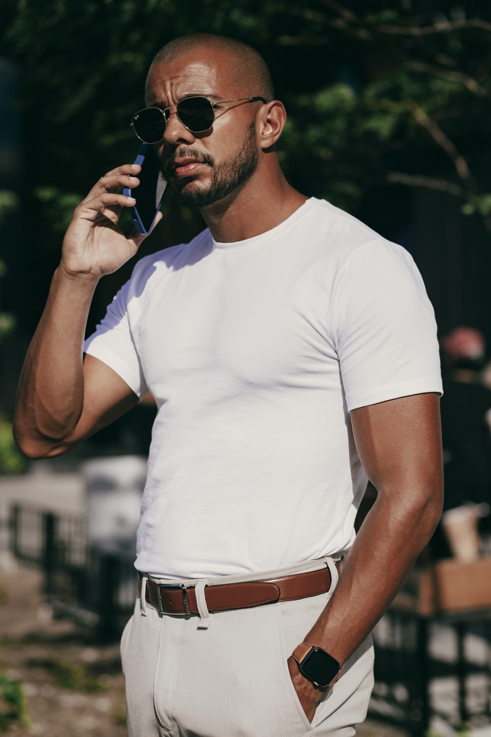 a man wearing sunglasses and holding a phone