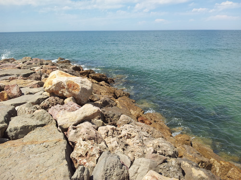 a rocky shoreline with blue water