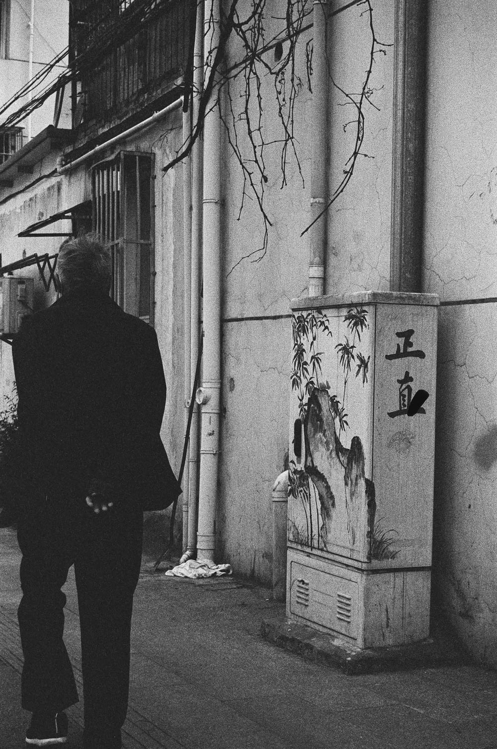 a man standing next to a wall with graffiti on it