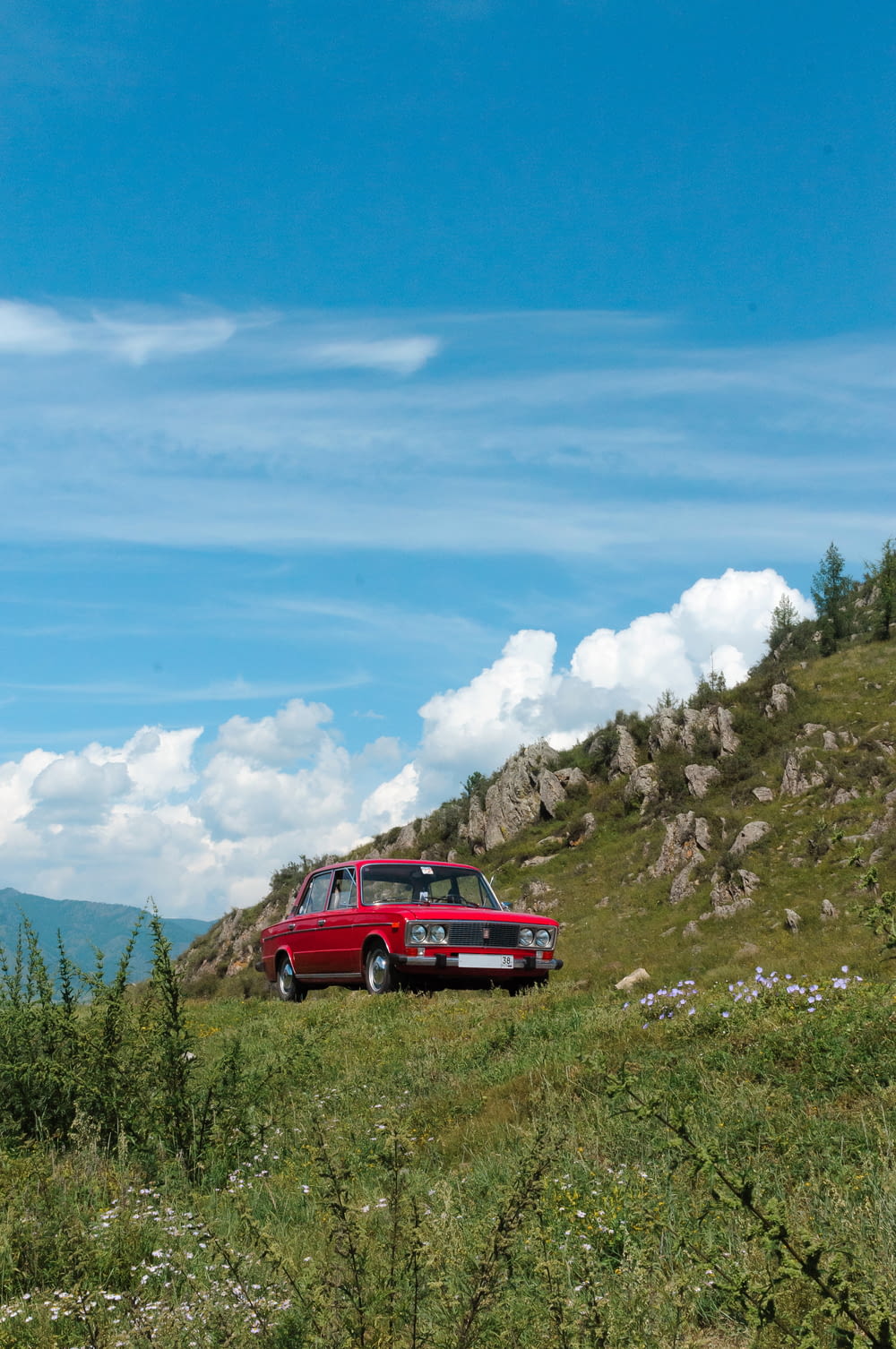a red car parked on a hill