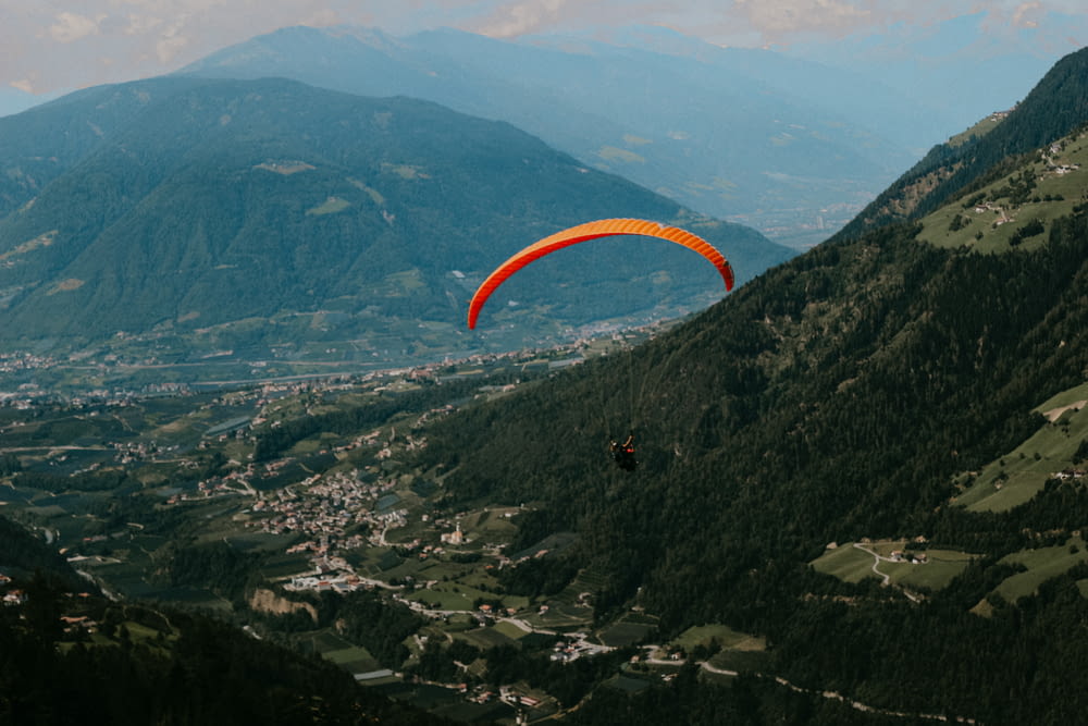 a person parachuting over a valley