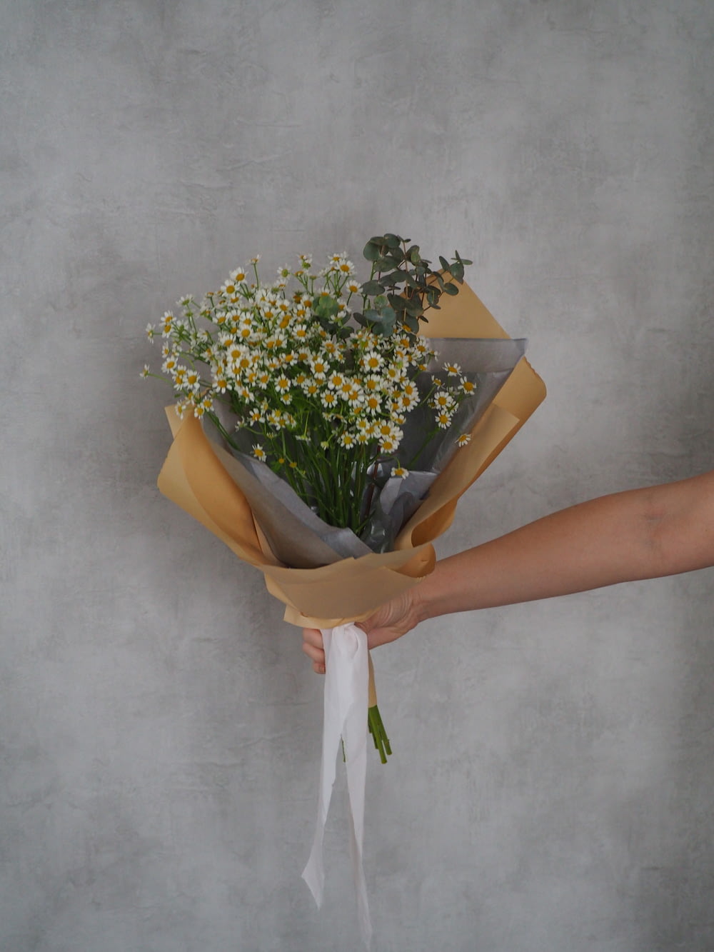 a hand holding a pot of flowers