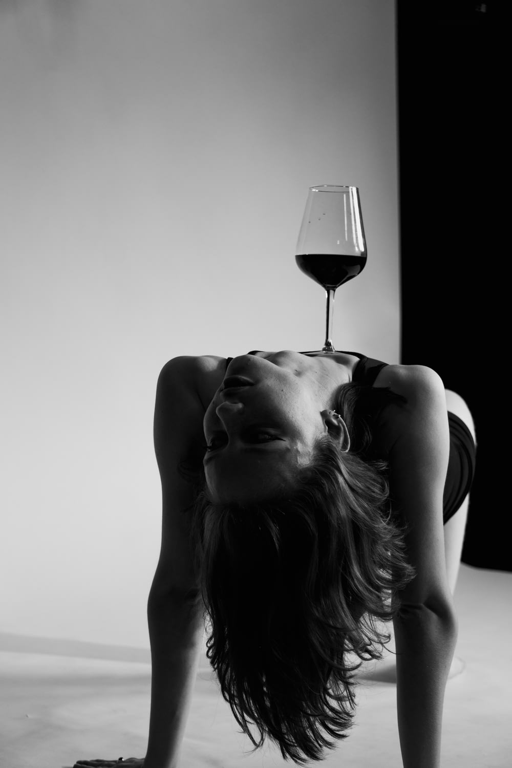 a person lying on the ground with a glass of wine on the head