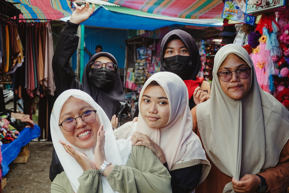 a group of people wearing head scarves posing for the camera