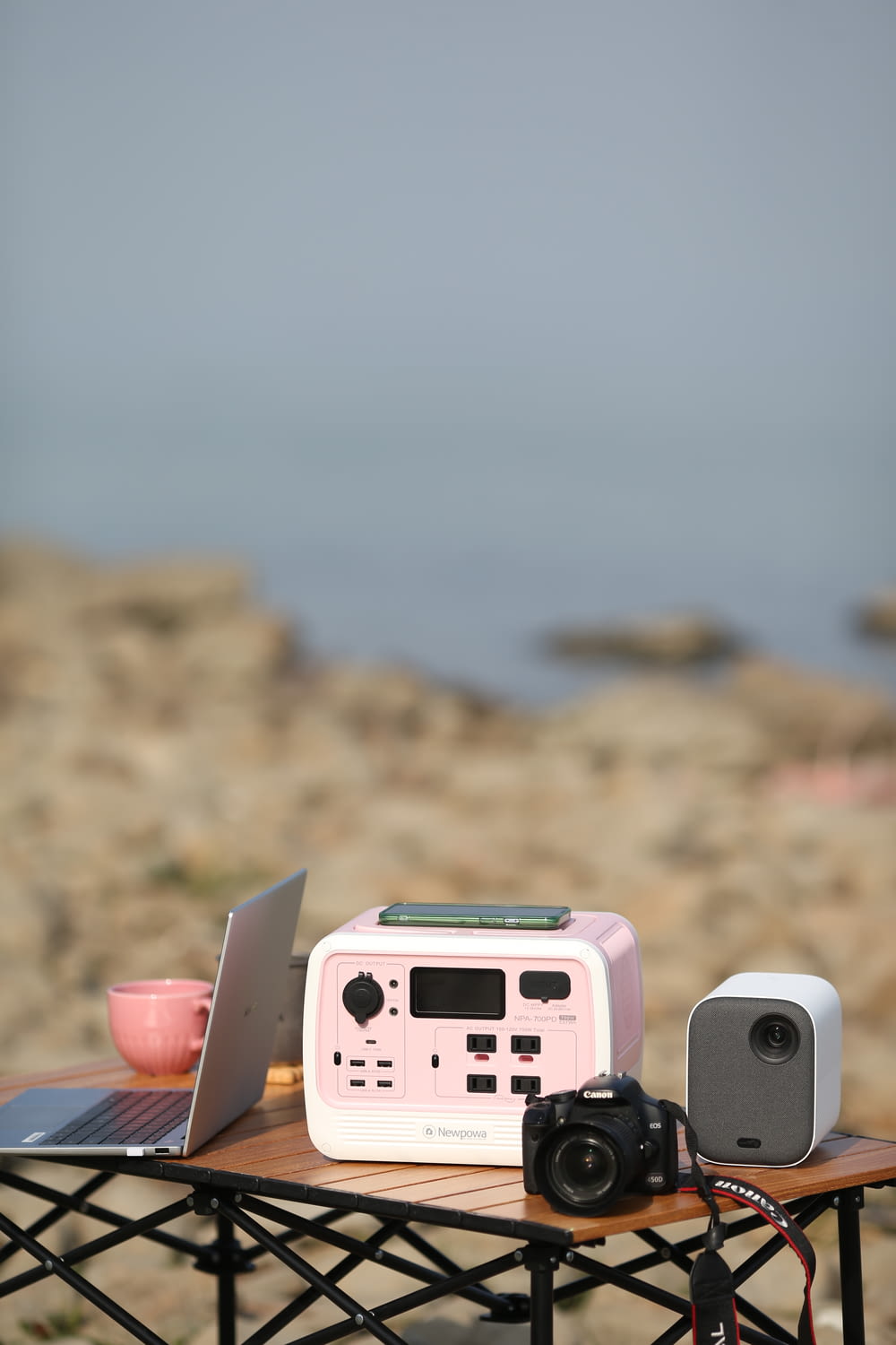 a pink and white toy car on a table with a camera and a camera