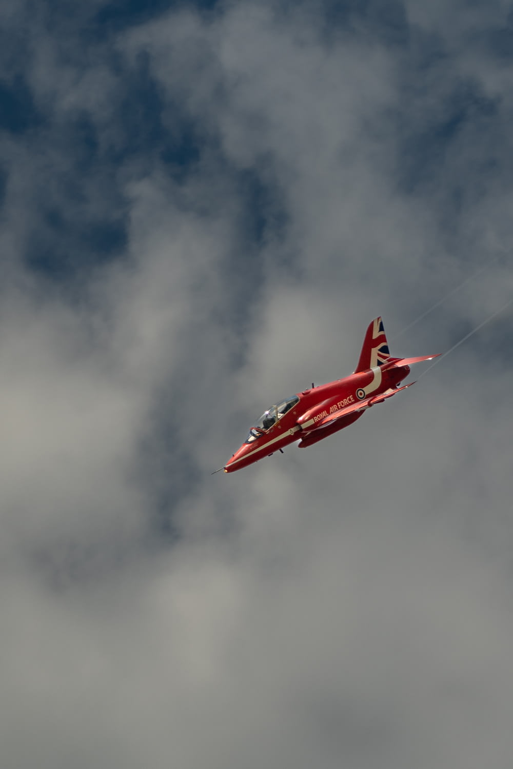 a red and white plane flying in the sky