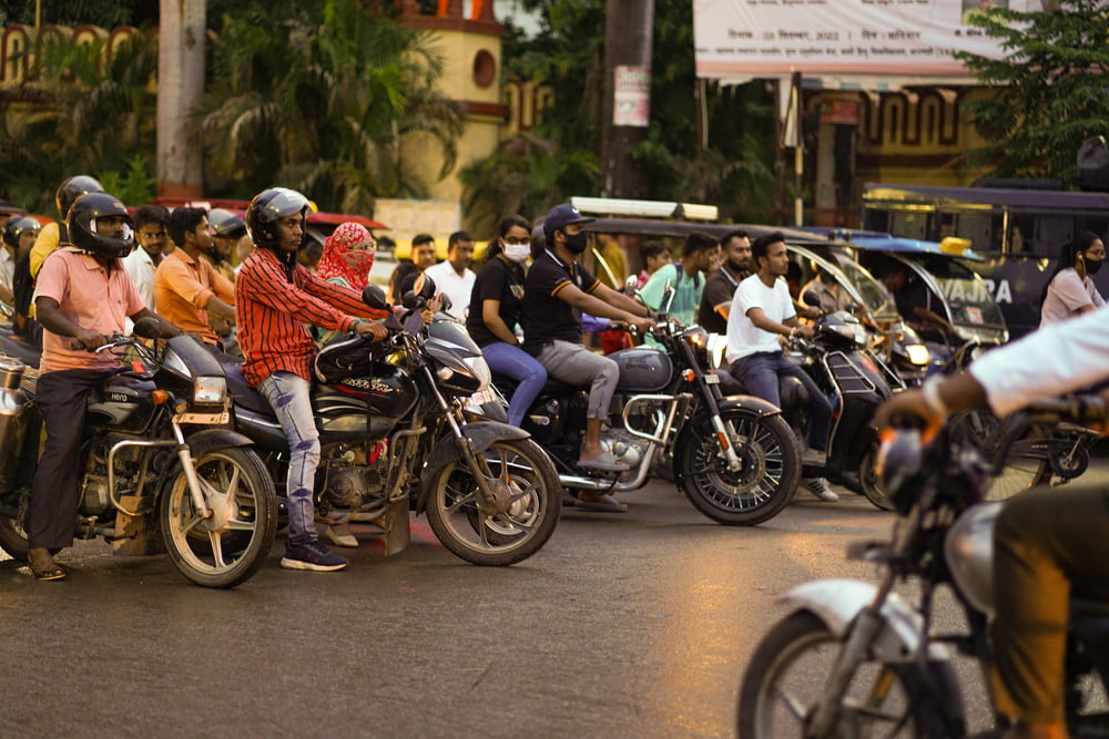a group of people ride motorcycles down a busy street