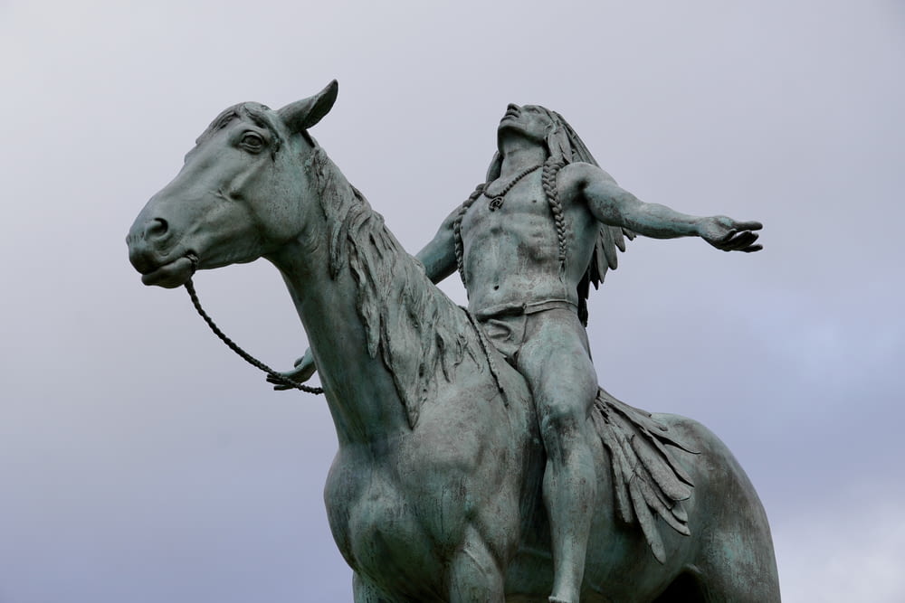 eine Statue einer Person, die auf einem Pferd reitet